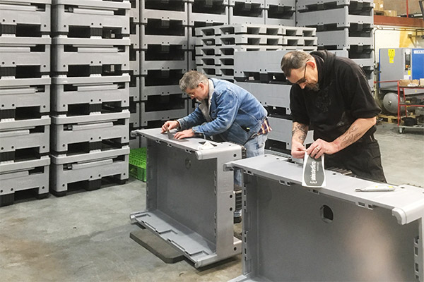 Workers in a factory fabricating plastic storage containers in the UK.
